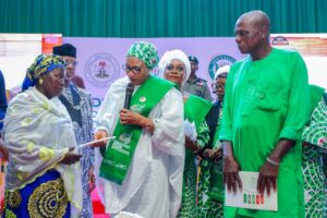 Wife of the Vice President, Hajiya Nana Shettima, presents a cash gift to a beneficiary of the Renewed Hope Initiative (RHI) Food Outreach Programme in Ogun State.